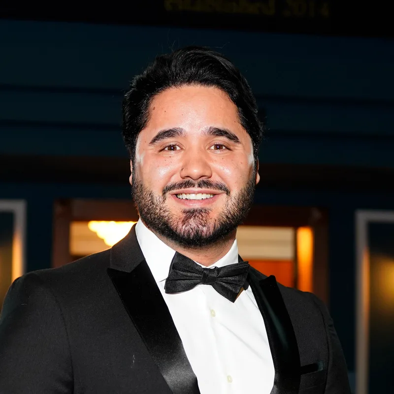 Alex Pinhol, CEO e fundador da Vynco, de smoking preto e gravata-borboleta na chegada de um evento de gala